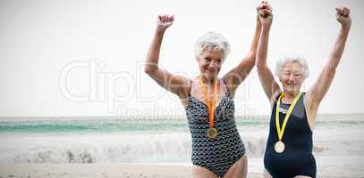 Composite image of portrait of happy swimmers with medals