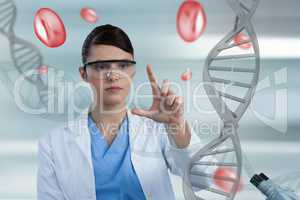 Doctor woman pointing with 3D DNA strands and cells