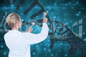 Doctor woman interacting with 3D DNA strands against blue background
