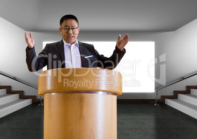 Businessman on podium speaking at conference with screen