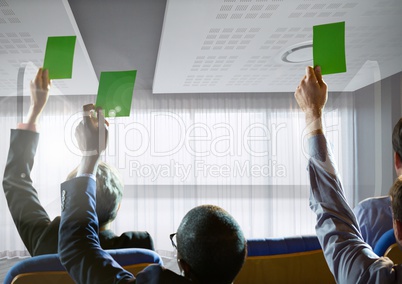 Business people holding green cards at conference by windows