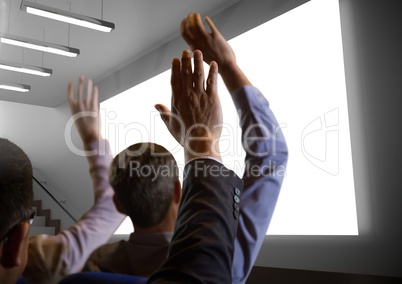 Business people with hands raised up in front of conference screen