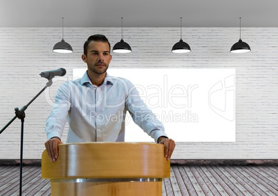 Businessman on podium speaking at conference with screen