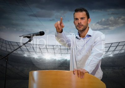 Businessman on podium speaking at conference with sports stadium