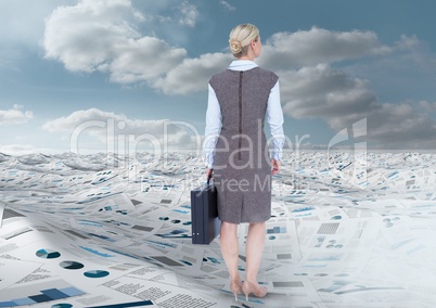 Businesswoman holding briefcase in sea of documents under sky clouds