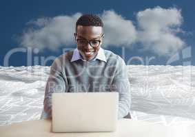 man on laptop in sea of documents under sky clouds
