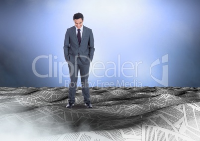 Businessman in sea of documents under sky clouds