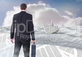 Businessman holding briefcase in sea of documents under sky clouds with paper boat