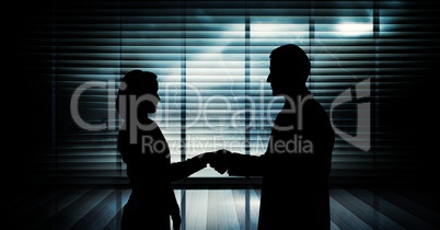 Business handshake silhouette against building Business handshake silhouette against building