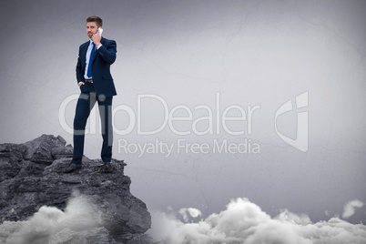 Composite image of portrait of businessman standing talking on smart phone