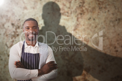 Composite image of portrait of smiling waiter with arms crossed