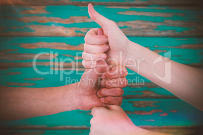 Composite image of cropped image of friends stacking fists