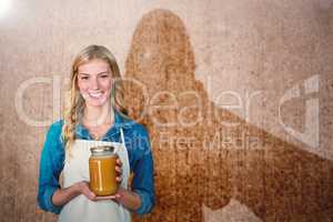 Composite image of portrait of young woman holding jar
