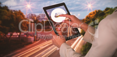 Composite image of businesswoman using digital tablet