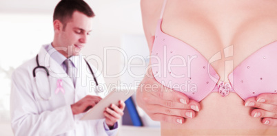 Composite image of mid section of woman in bra touching breast for cancer awareness