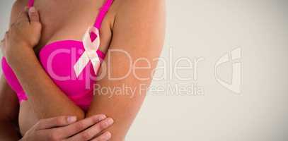 Mid section of woman in pink bra with ribbon