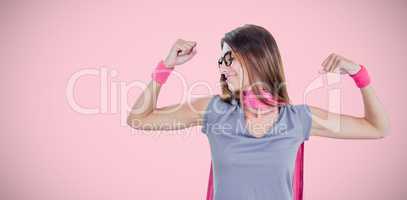 Composite image of smiling woman in superhero costume while flexing muscles