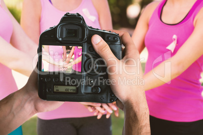 Composite image of cropped image of hands holding camera