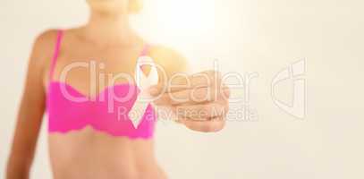 Mid section of woman in pink bra holding ribbon