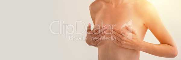 Mid section of sensuous woman checking breasts
