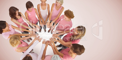 Composite image of female friends supporting breast cancer awareness