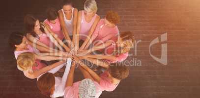 Composite image of female friends supporting breast cancer