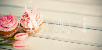 High angle view of Breast Cancer Awareness pink ribbons on cupcakes with tulips