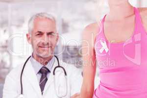 Composite image of mid section of woman wearing breast cancer awareness ribbon