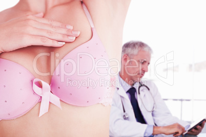Composite image of mid section of woman in bra for breast cancer awareness