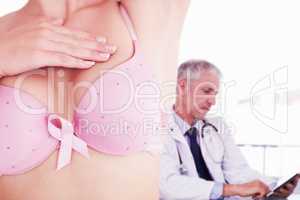 Composite image of mid section of woman in bra for breast cancer awareness