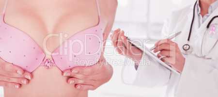 Composite image of mid section of woman in bra touching breast for cancer awareness