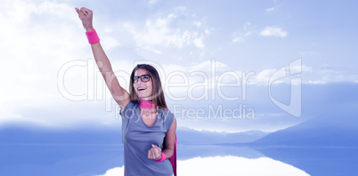 Composite image of smiling woman in superhero costume with arm raised
