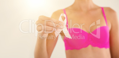 Mid section of sensuous woman in pink bra holding ribbon