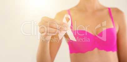 Mid section of sensuous woman in pink bra holding ribbon