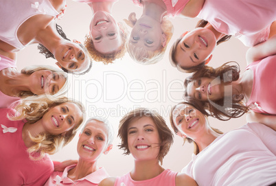 Composite image of low angle portrait of female friends supporting breast cancer