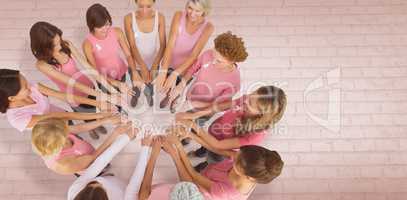 Composite image of female friends supporting breast cancer awareness