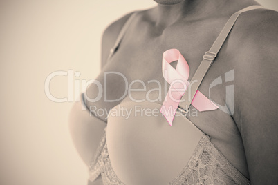 Mid section of young woman in pink bra with ribbon