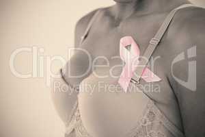 Mid section of young woman in pink bra with ribbon