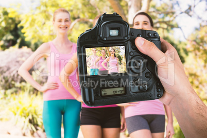 Composite image of cropped hand of photographer holding camera