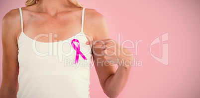 Mid section of young woman pointing at pink ribbon