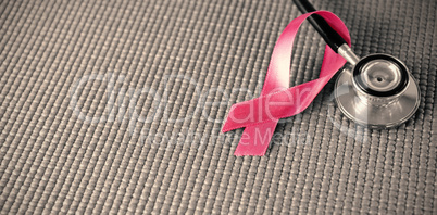 High angle view of stethoscope by pink Breast Cancer Awareness ribbon High angle view of stethoscope by pink Breast Cancer Awareness ribbon