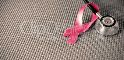 High angle view of stethoscope by pink Breast Cancer Awareness ribbon