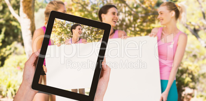 Composite image of close-up of hands holding digital tablet