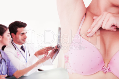 Composite image of mid section of woman in bra touching breast