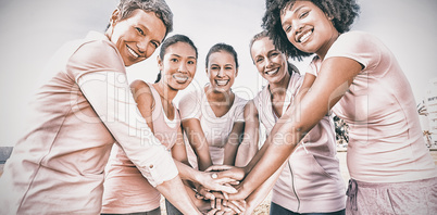 Women wearing pink for breast cancer and putting hands together