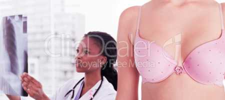 Composite image of mid section of woman wearing pink bra for breast cancer social issue