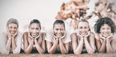 Smiling women lying in row for breast cancer awarness