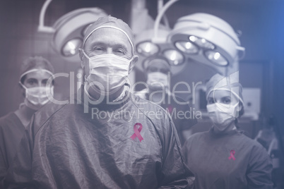 Composite image of smiling surgeon posing with a team