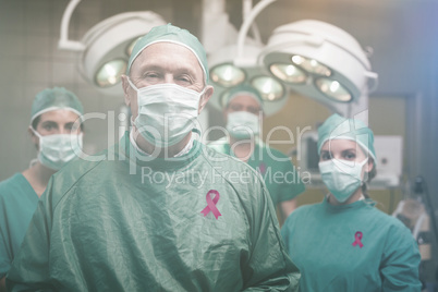 Composite image of smiling surgeon posing with a team
