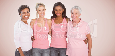 Composite image of portrait of happy women supporting breast cancer social issue